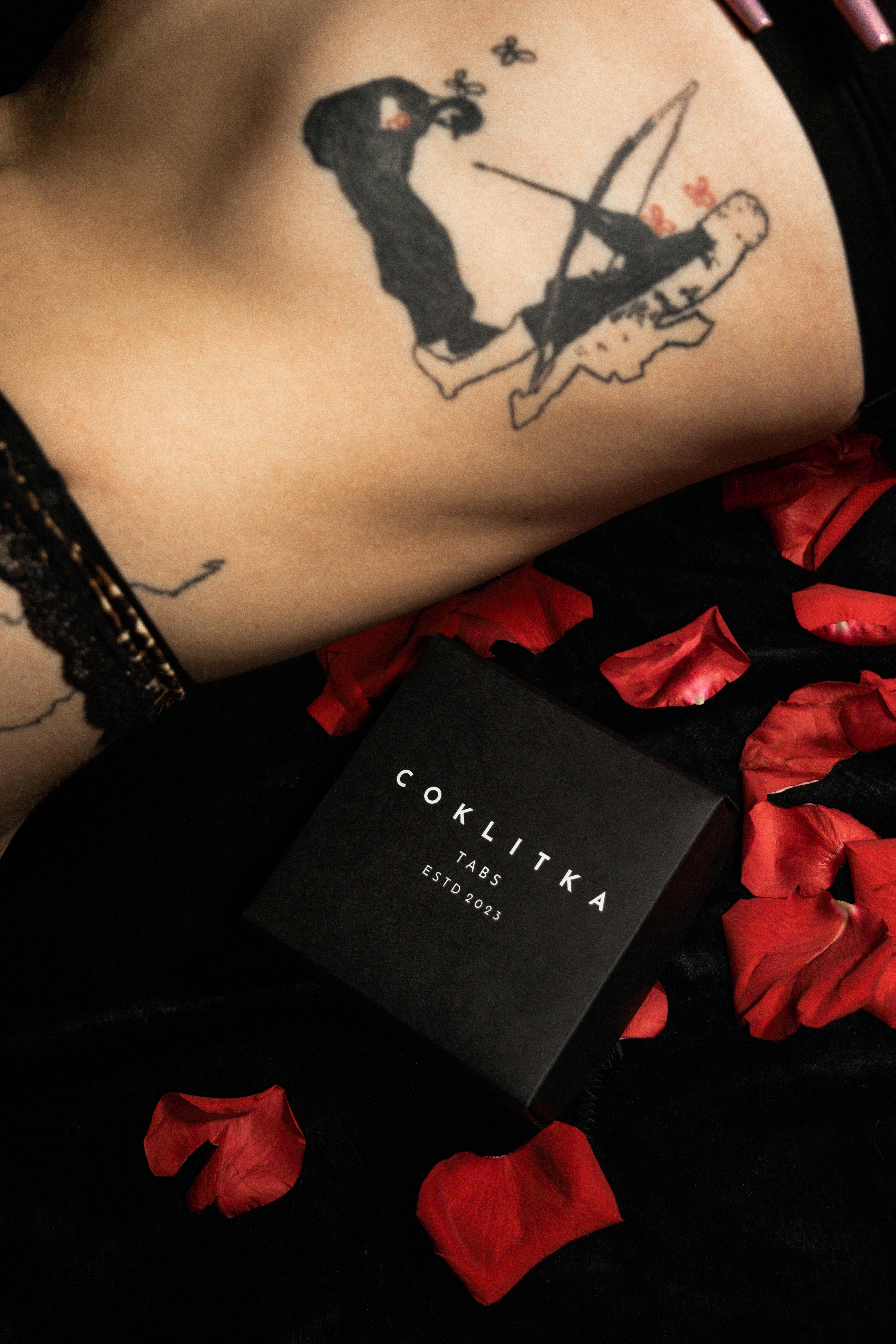 Sexuálna čokoláda a v pozadí je blízky záber na tetovanie so šípom Amora (lásky).
